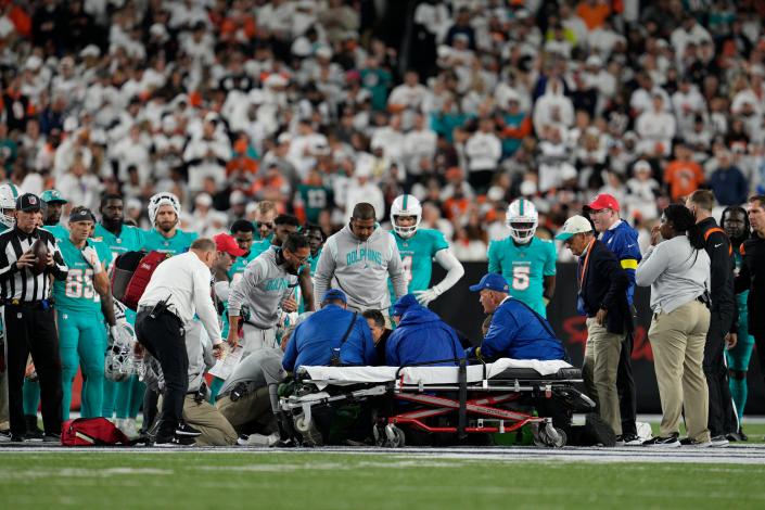 Trainers attend to Dolphins QB Tua Tagovailoa after he suffered head and neck injuries during the game against the Bengals.