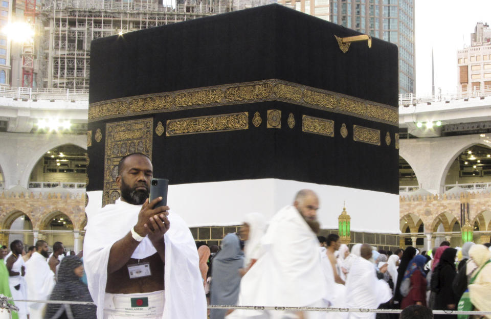 A Bangladeshi pilgrim poses for a selfie in front of the Kaaba, the cubic building at the Grand Mosque, in the Saudi Arabia's holy city of Mecca, Tuesday, July 5, 2022. Saudi Arabia is expected to receive one million Muslims to attend Hajj pilgrimage, which will begin on July 7, after two years of limiting the numbers because coronavirus pandemic. (AP Photo/Amr Nabil)