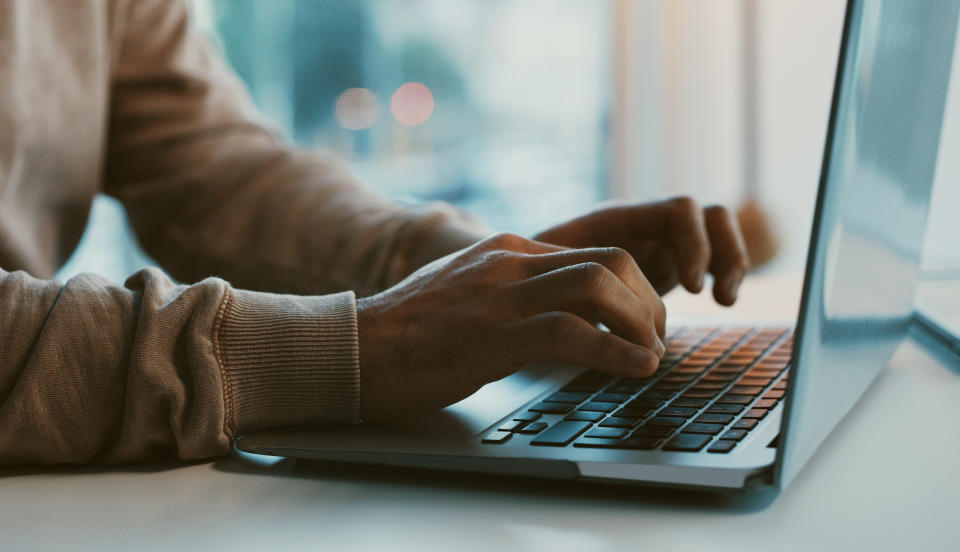 hands typing on a computer from home