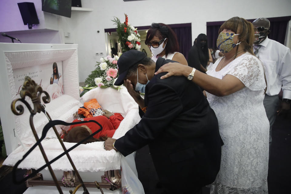 Lydia Nunez father Samuel Nunez, center, in black cries next to her casket during a funeral for Nunez, who died from COVID-19, at the Metropolitan Baptist Church Tuesday, July 21, 2020, in Los Angeles. (AP Photo/Marcio Jose Sanchez)