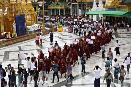 Ethnic Rakhine demonstrators and Buddhist monks hold signs as they gather at the Shwedagon pagoda after unrest flared in the western Myanmar state. Security forces have tried to restore order to a Myanmar state placed under emergency rule after a wave of deadly religious violence, as the United Nations evacuated foreign workers