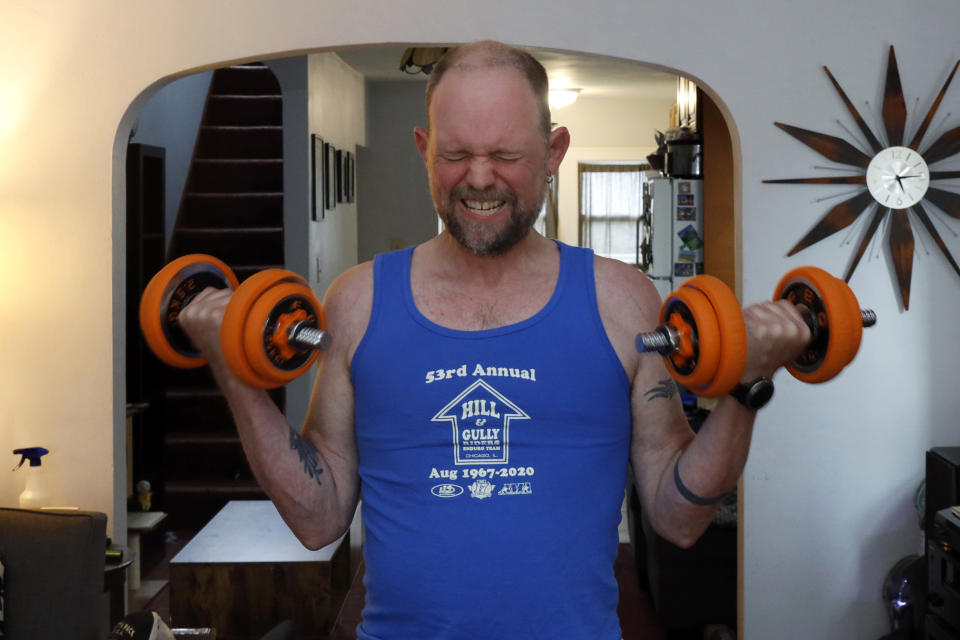 Christian Hainds performs curls as he works out at his home in Hammond, Ind., Monday, June 7, 2021. Health officials have warned since early on in the pandemic that obesity and related conditions such as diabetes were risk factors for severe COVID-19. It wasn't until he was diagnosed as diabetic around the start of the pandemic that he felt the urgency to make changes. Hainds lost about 50 pounds during the pandemic, and at 180 pounds and 5 feet, 11 inches tall is no longer considered obese. (AP Photo/Shafkat Anowar)