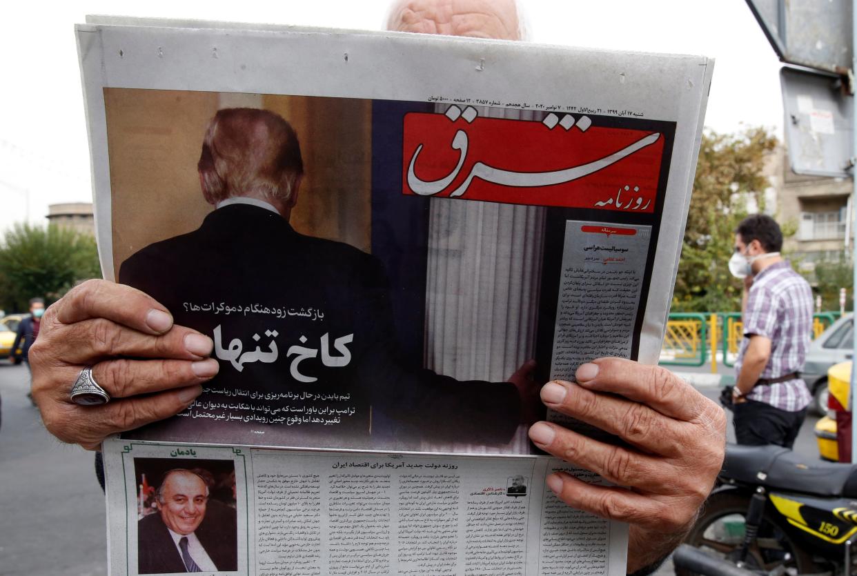 <p>A man reads a copy of Iranian daily newspaper ‘Shargh’ with a picture of outgoing US president Donald Trump</p> (EPA)