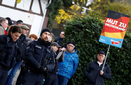 Police stands in front of supporters of the anti-immigrant Alternative for Germany (AFD), blocking the entrance to a property which was used by a German political art group to built a pared-down version of Berlin's Holocaust memorial next to the home of AFD senior member Bjoern Hoecke in the village of Bornhagen, Germany, November 22, 2017. REUTERS/Kai Pfaffenbach