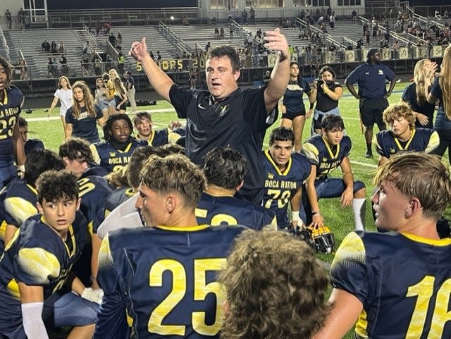 Boca Raton coach Alex Savakinas addresses his team after getting an ice-water bath to celebrate the Bobcats' 24-21 win over Santaluces on Friday night.