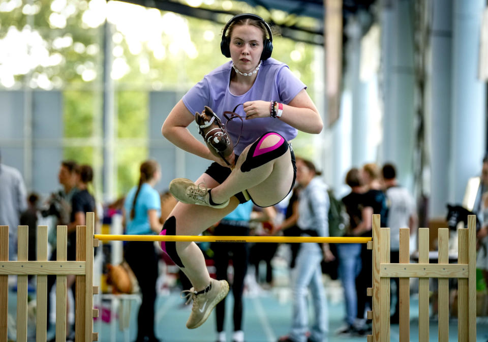 A participant clears the bar during the first German Hobby Horsing Championship in Frankfurt, Germany, Saturday, Sept. 14, 2024. (AP Photo/Michael Probst)