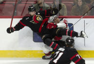 Ottawa Senators defenseman Thomas Chabot, left, collides with New Jersey Devils left wing Tomas Nosek, right, during third-period NHL hockey game action in Ottawa, Ontario, Saturday, April 6, 2024. (Adrian Wyld/The Canadian Press via AP)