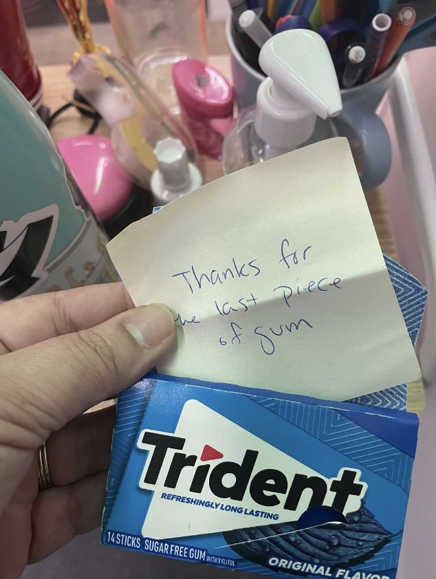 Note on pack of Trident gum with handwritten message "Thanks for the last piece of gum" surrounded by office supplies