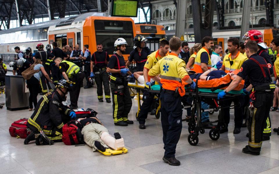 firefighters and paramedics treat injured people at Francia Railway Station - Credit: EFE