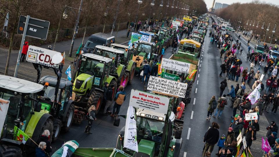 Demonstranten und Bauern mit ihren Traktoren stehen auf der Straße des 17. Juni in Berlin.