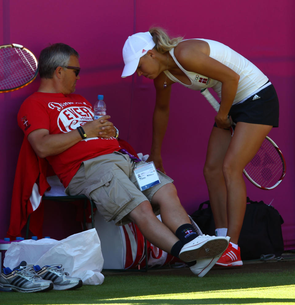 Caroline Wozniacki of Denmark speaks with her father and coach Piotr Wozniacki during a practice session ahead of the 2012 London Olympic Games at the All England Lawn Tennis and Croquet Club in Wimbledon on July 24, 2012 in London, England. (Photo by Clive Brunskill/Getty Images)