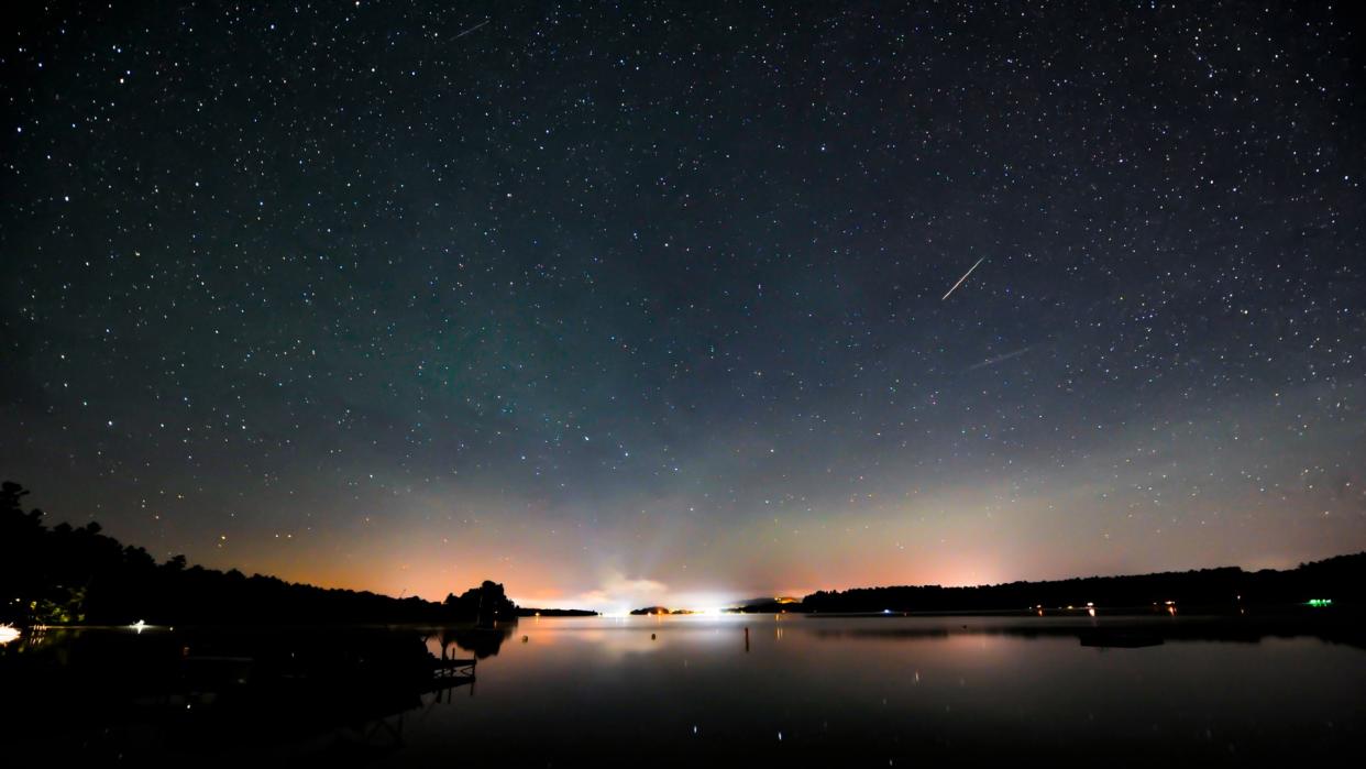 a bright meteorite streaks over a lake 