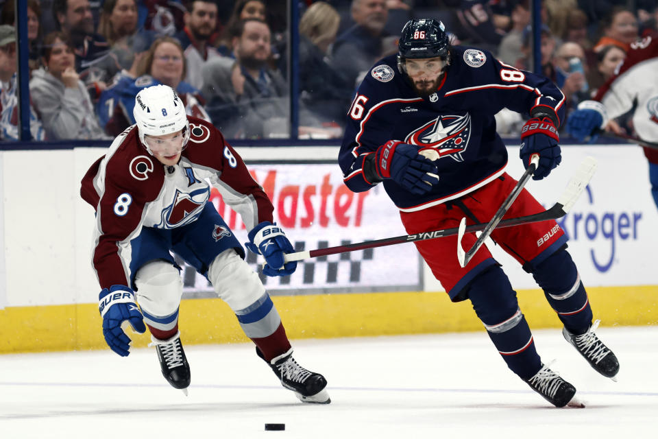 Columbus Blue Jackets forward Kirill Marchenko, right, chases the puck in front of Colorado Avalanche defenseman Cale Makar during the second period of an NHL hockey game in Columbus, Ohio, Monday, April 1, 2024. (AP Photo/Paul Vernon)