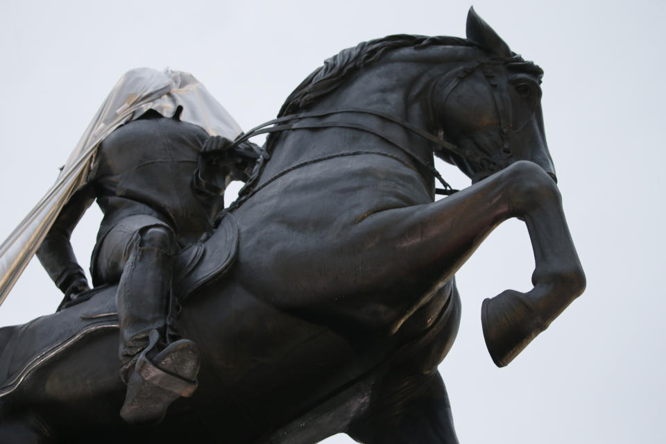 A tarp still covers part of a statue during the unveiling ceremony for a statue titled Rumor's of War by artist Kehinde Wiley at the Virginia Museum of Dine arts in Richmond, Va., Tuesday, Dec. 10, 2019. Unfortunately the tarp covering the statue got stuck on the statue during the ceremony. (AP Photo/Steve Helber)