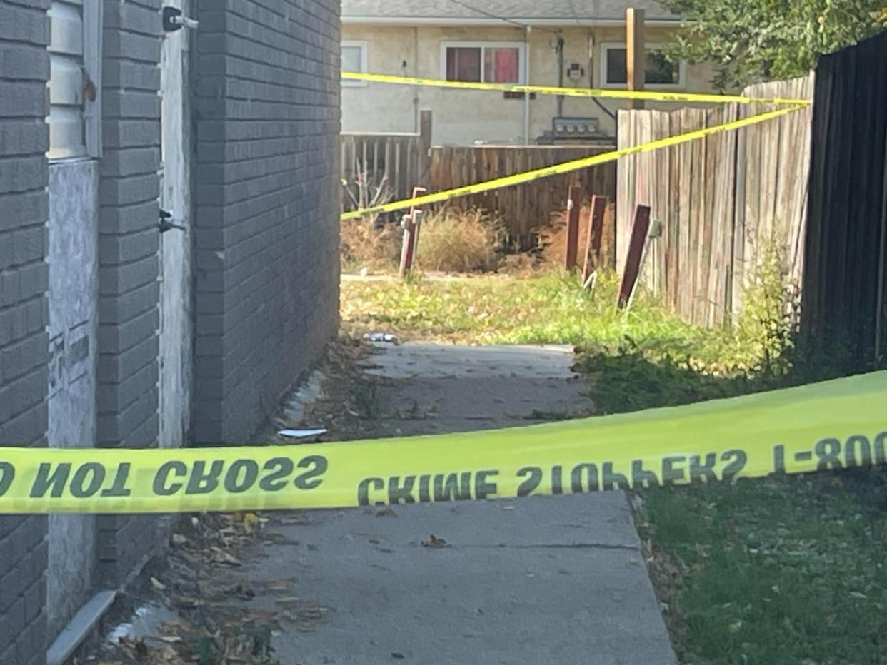 Police tape secures a crime scene in Saskatoon on Avenue R South where a man's body was found in Sept. 2023. (Dan Zakreski/CBC - image credit)