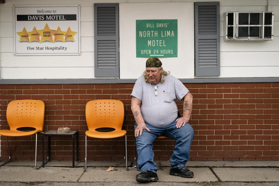 Jeff Drummond, who now resides in a motel after being displaced by the East Palestine train derailment sits outside his room in North Lima, Ohio, Monday, April 3, 2023. "I have nothing here," says Drummond. "So it's trying to find something to keep yourself busy, to keep from going crazy." (AP Photo/Matt Rourke)