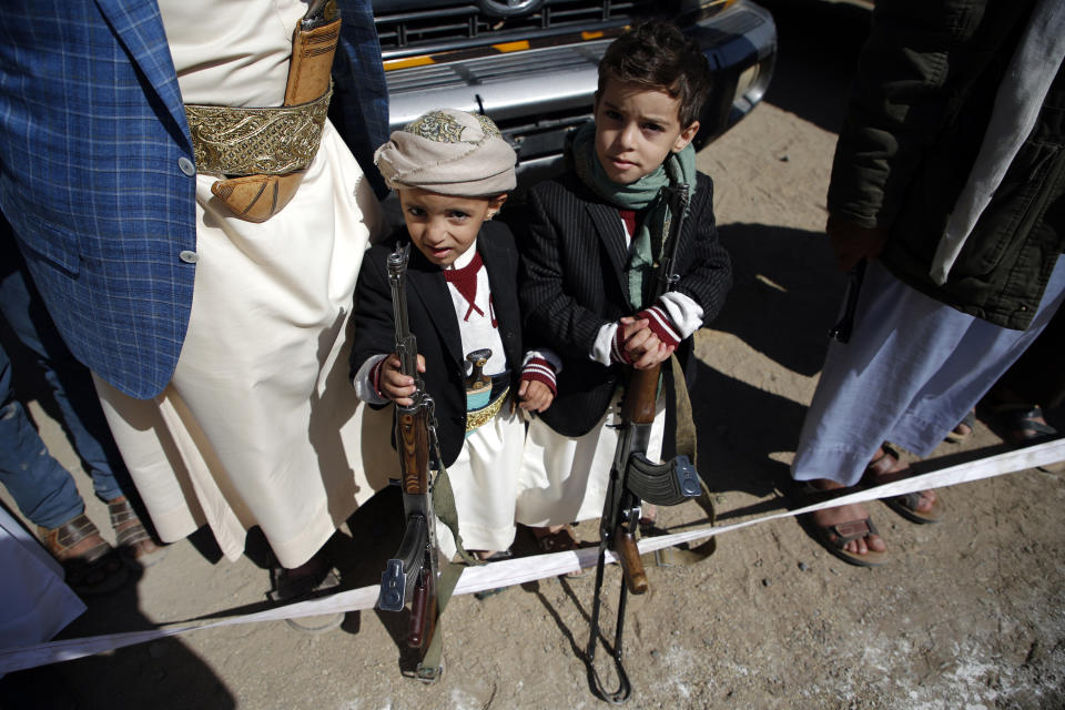 Niños sosteniendo los rifles de sus padres en Yemen, donde en los últimos 7 años han muerto o han sido heridos 10.200 niños, según UNICEF, aunque las cifras son mayores. [Foto: Mohammed HUWAIS/AFP]