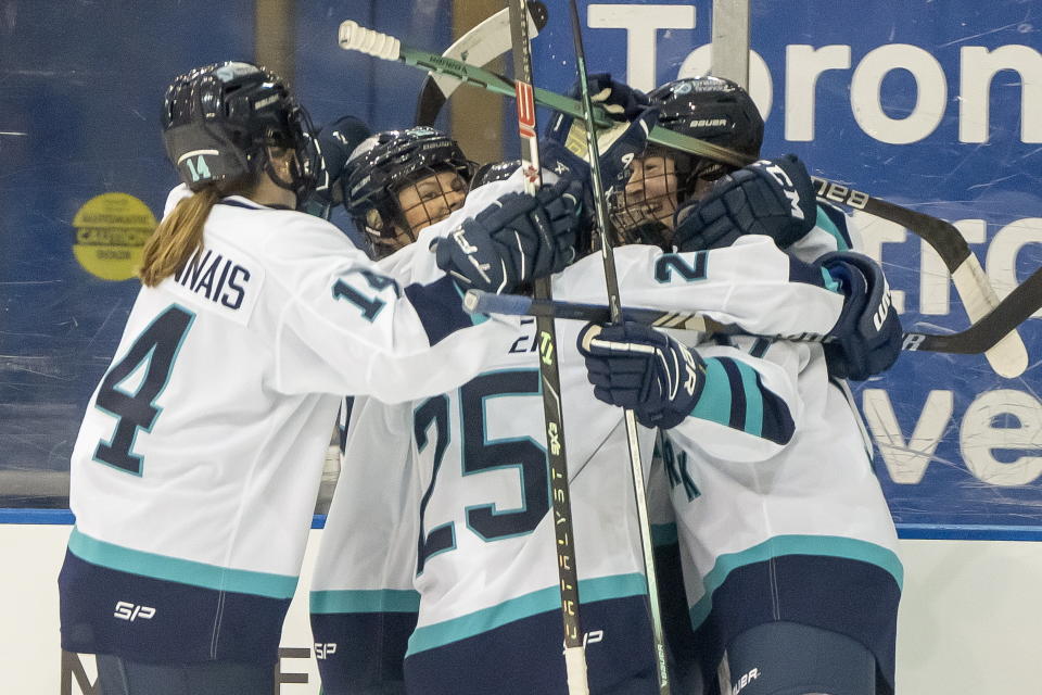 New York defender Ella Shelton, right, is congratulated by teammates Jamie Bourbonnais (14), Paetyn Levis (19) and Alex Carpenter (25) after scoring the first goal in PWHL history against Toronto during first period hockey game in Toronto on Monday, Jan. 1, 2024. (Frank Gunn/The Canadian Press via AP)