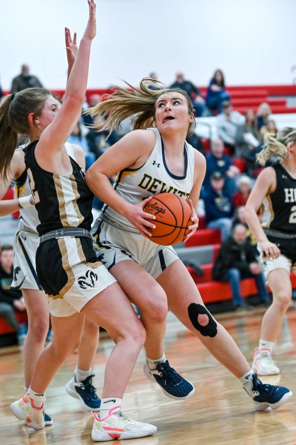 DeWitt's Carly Dennis, right, moves to the basket as Holt's Abigail Metzger defends during the second quarter on Thursday, March 9, 2023, at Coldwater High School.