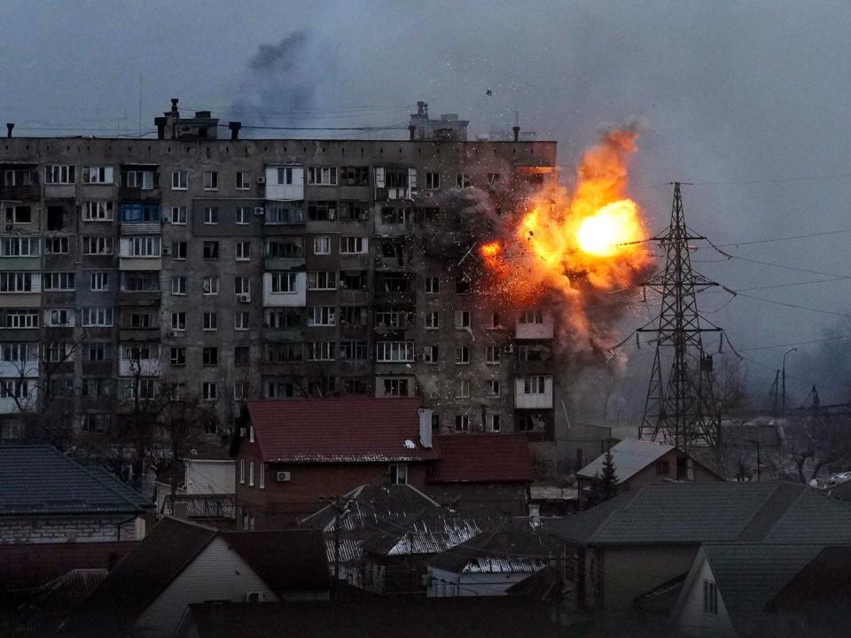 An explosion is seen in an apartment building after Russian's army tank fires in Mariupol, Ukraine, Friday, March 11, 2022.