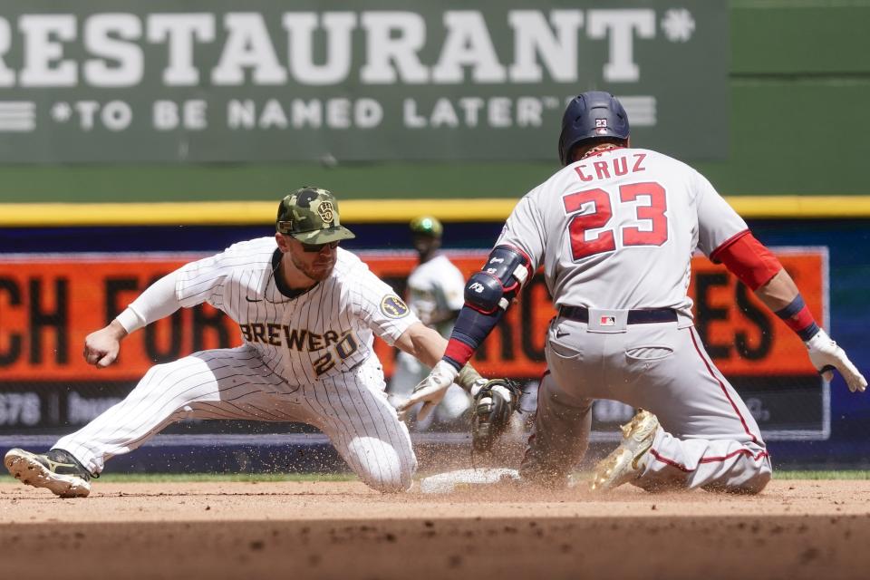Milwaukee Brewers' Mike Brosseau tags out Washington Nationals' Nelson Cruz at second as he tries to stretch a single into a double during the fourth inning of a baseball game Sunday, May 22, 2022, in Milwaukee. (AP Photo/Morry Gash)