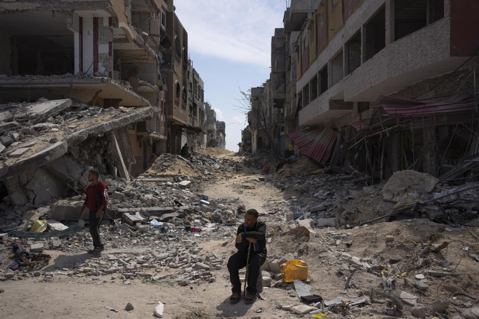 Palestinians walk through the destruction in the wake of an Israeli air and ground offensive in Khan Younis, southern Gaza Strip, Monday, April 8, 2024. Israel says it has withdrawn its last ground troops from the city, ending a four-month operation. (AP Photo/Fatima Shbair)