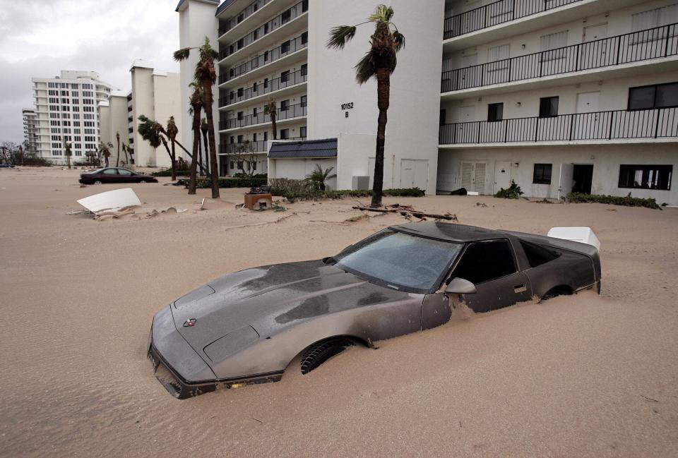 A corvette is covered in sand from Hurricane Jeanne's storm surge outside the Ocean Rise condos on Hutchinson Island, Florida on September 26, 2004.