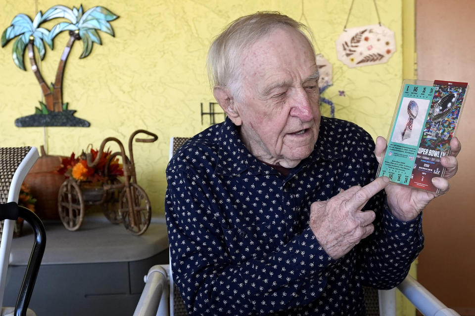 Tom Henschel holds up tickets to quarterback Tom Brady's first and last Super Bowl games during an interview at his home Thursday, Jan. 25, 2024, in Tampa, Fla. Three football fans in their 80s are keeping their membership in the "never missed a Super Bowl" club. (AP Photo/Chris O'Meara)