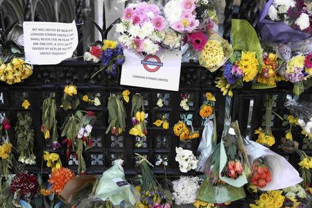 Floral tributes are tied to a fence in Parliament Square following the attack in Westminster earlier in the week, in central London, Britain March 26, 2017. REUTERS/Neil Hall