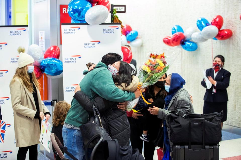 Family members embrace on 8 November 2021 as they are reunited at JFK International Airport after borders reopened between the US and the UK (Reuters)