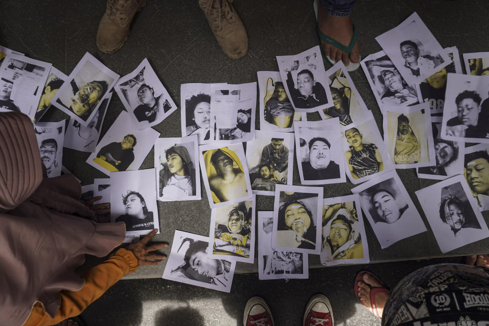 Personas que buscan a sus familiares desaparecidos inspeccionan las fotos de las víctimas de una estampida durante un partido de fútbol el día anterior en Malang, Java Oriental, Indonesia, el 2 de octubre de 2022. La estampida de pánico durante el partido de fútbol dejó más de 100 muertos, la mayoría de los cuales murieron pisoteados después de que la policía lanzara gases lacrimógenos para prevenir violencia. (AP Foto/Dicky Bisinglasi)People looking for their relatives inspect photos of victims of the soccer match stampede that occurred the day before in Malang, East Java, Indonesia, on Oct. 2, 2022. Panic at the soccer match left over 100 people dead, most of whom were trampled to death after police fired tear gas to prevent violence. (AP Photo/Dicky Bisinglasi)