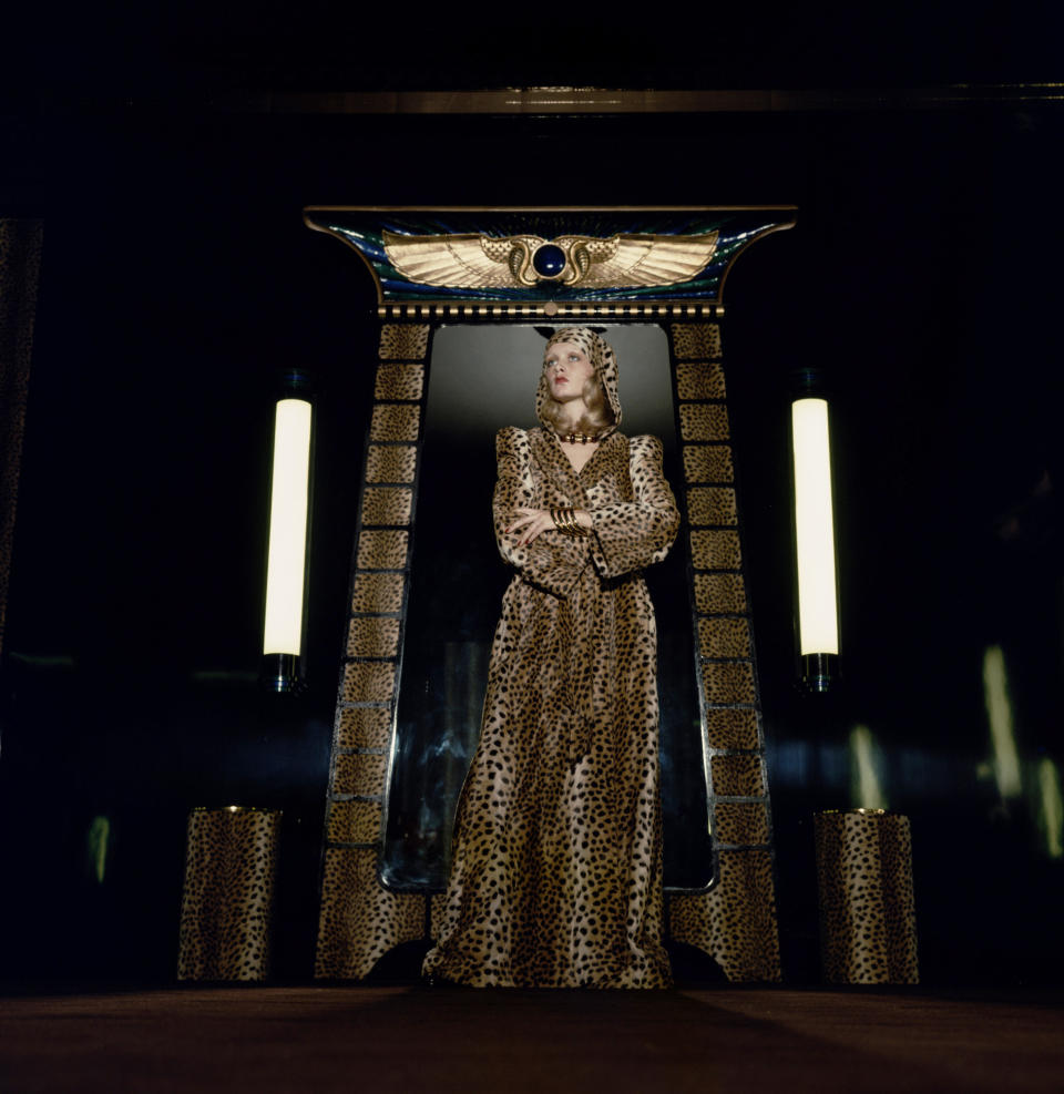 English model Twiggy models a leopardskin robe against an ancient Egyptian-style backdrop at Biba's Kensington store, 1971.