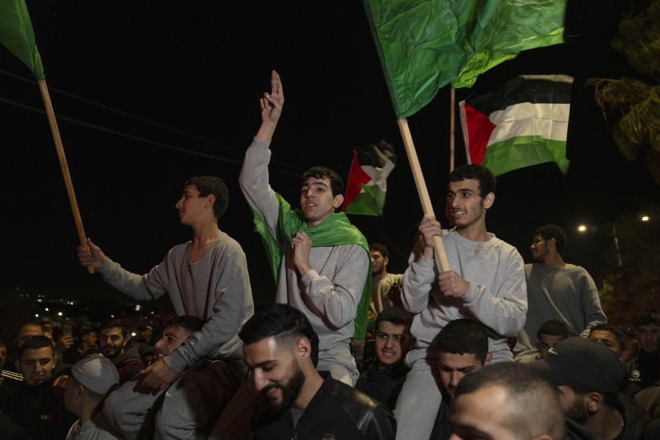 Former Palestinian prisoners who were released by the Israeli authorities, fly Palestinian and Hamas flags while they are carried on the shoulders upon their arrival in the West Bank town of Beitunia, Friday, Nov. 24, 2023. The release came on the first day of a four-day cease-fire deal between Israel and Hamas during which the Gaza militants have pledged to release 50 hostages in exchange for 150 Palestinians imprisoned by Israel. (AP Photo/Nasser Nasser)