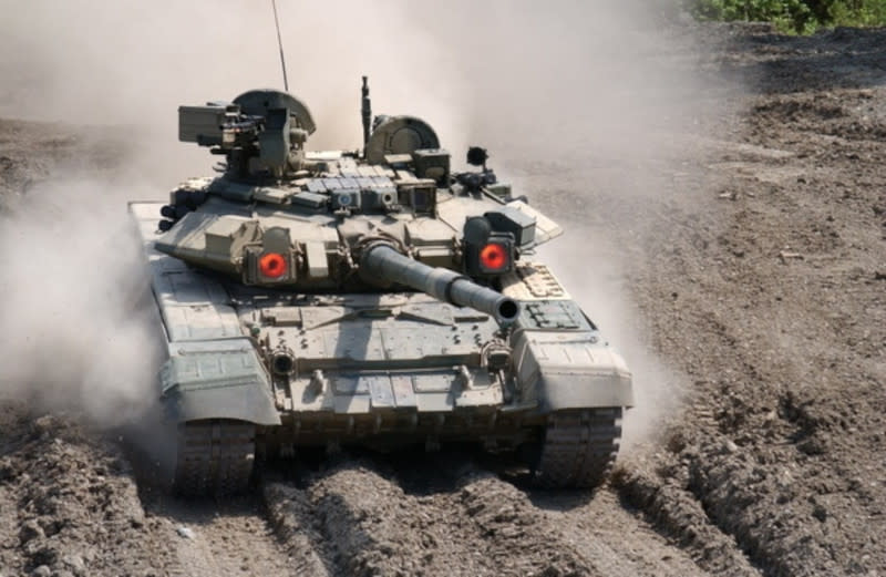 A T-90 tank with the two infrared emitters that are part of its Shtora-1 system on either side of the barrel of its main gun switched on. <em>Nicknamefqoff via Wikimedia</em>