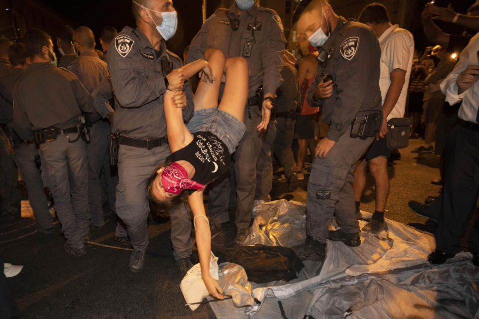 Israeli police officers detain a protester during a demonstration against Israeli Prime Minister Benjamin Netanyahu near the Prime Minister's residence in Jerusalem, Sunday, Sept. 20, 2020. (AP Photo/Sebastian Scheiner)