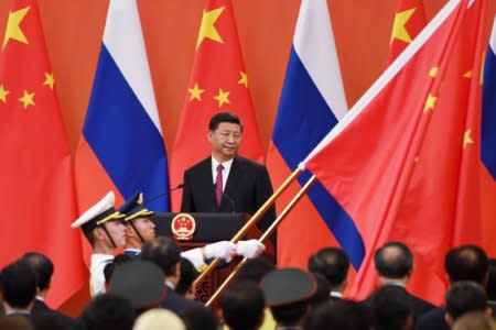 Chinese President Xi Jinping (C) looks on as Chinese soldiers carry the Chinese flag during a medal presentation ceremony in the Great Hall of the People in Beijing, China June 8, 2018. Greg Baker/Pool/via REUTERS