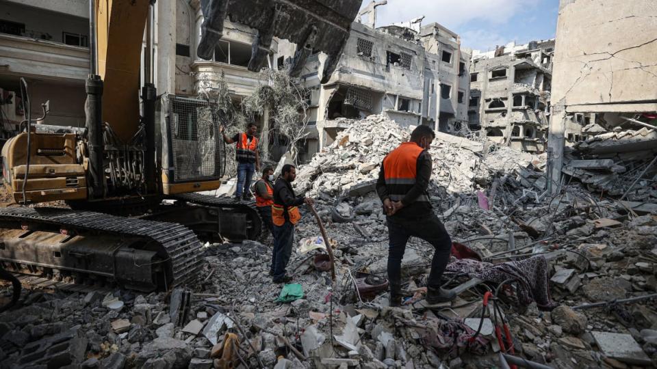 A photo including Palestinians searching for their belongings among the rubble in Gaza City