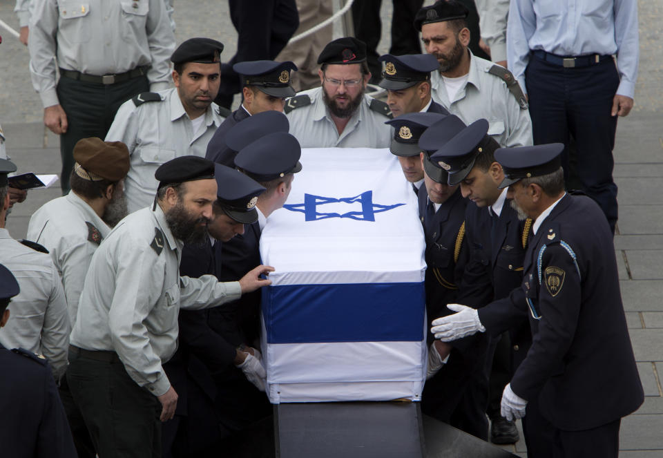 Members of the Knesset guard carry the coffin of former Israeli Prime Minister Ariel Sharon at the Knesset plaza, in Jerusalem, Sunday, Jan. 12, 2014. Sharon, the hard-charging Israeli general and prime minister who was admired and hated for his battlefield exploits and ambitions to reshape the Middle East, died Saturday, eight years after a stroke left him in a coma from which he never awoke. He was 85. (AP Photo/Oded Balilty)