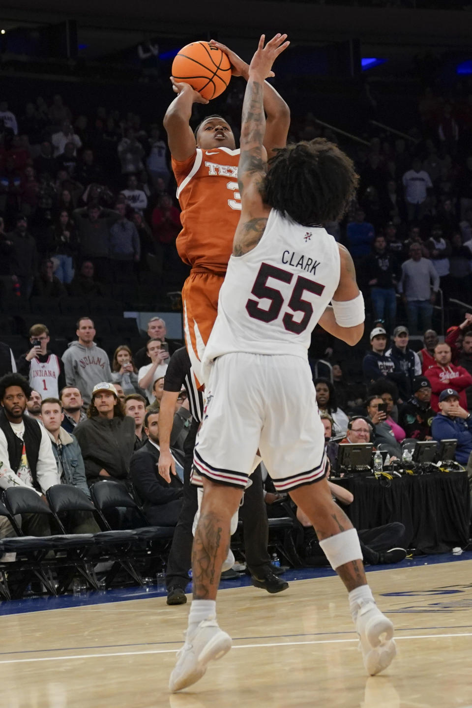 Texas's Max Abmas, left, puts up the wining shot over Louisville's Skyy Clark during the second half of an NCAA college basketball game, Sunday, Nov. 19, 2023, in New York. (AP Photo/Seth Wenig)