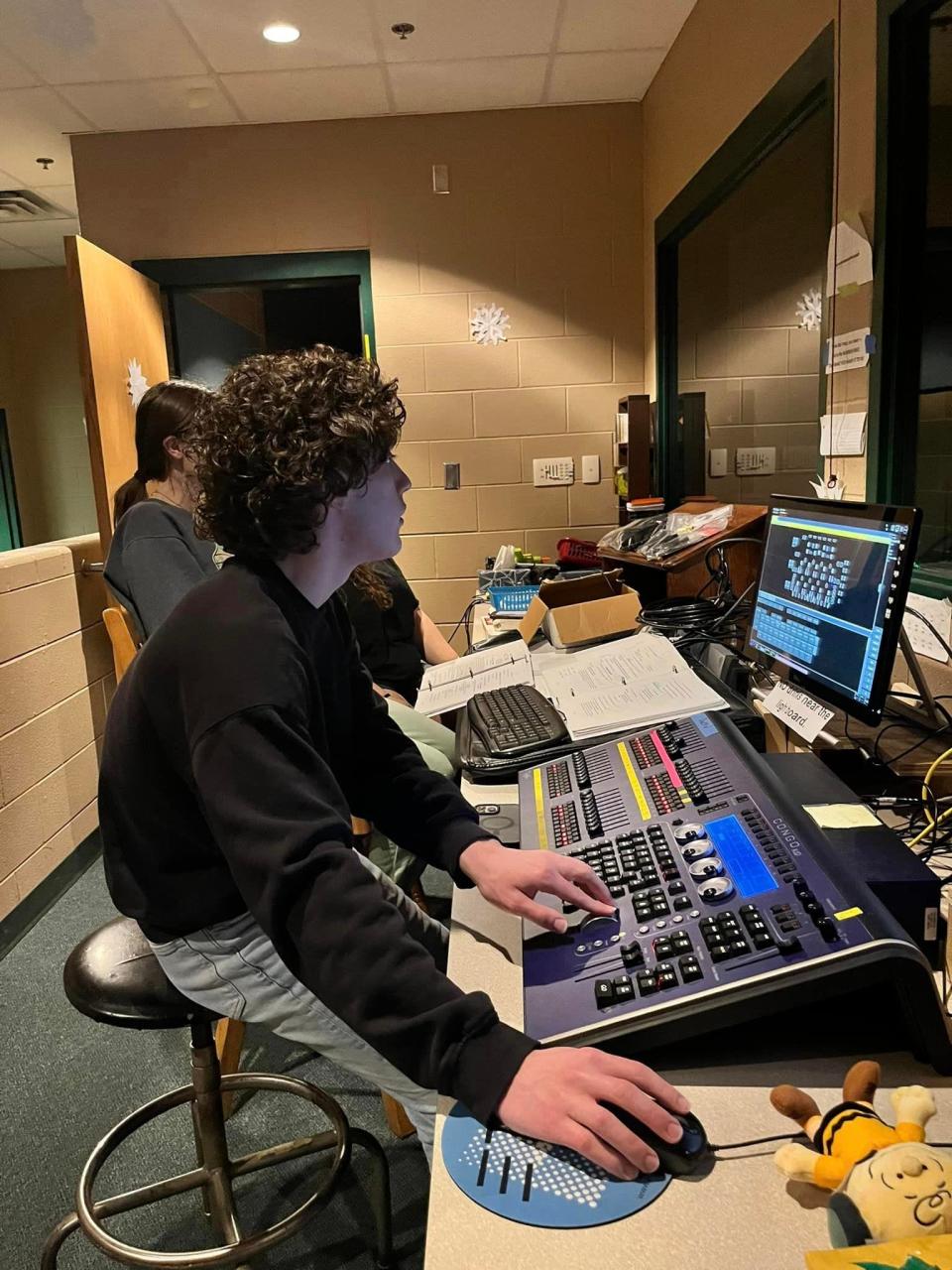 Wyatt Angel, a student from Salina Central High, works on the light board at the Salina South for the Sacred Heart production of "You're a Good Man Charlie Brown." Several people in the theater community in Salina help moved the show on the day of its opening.