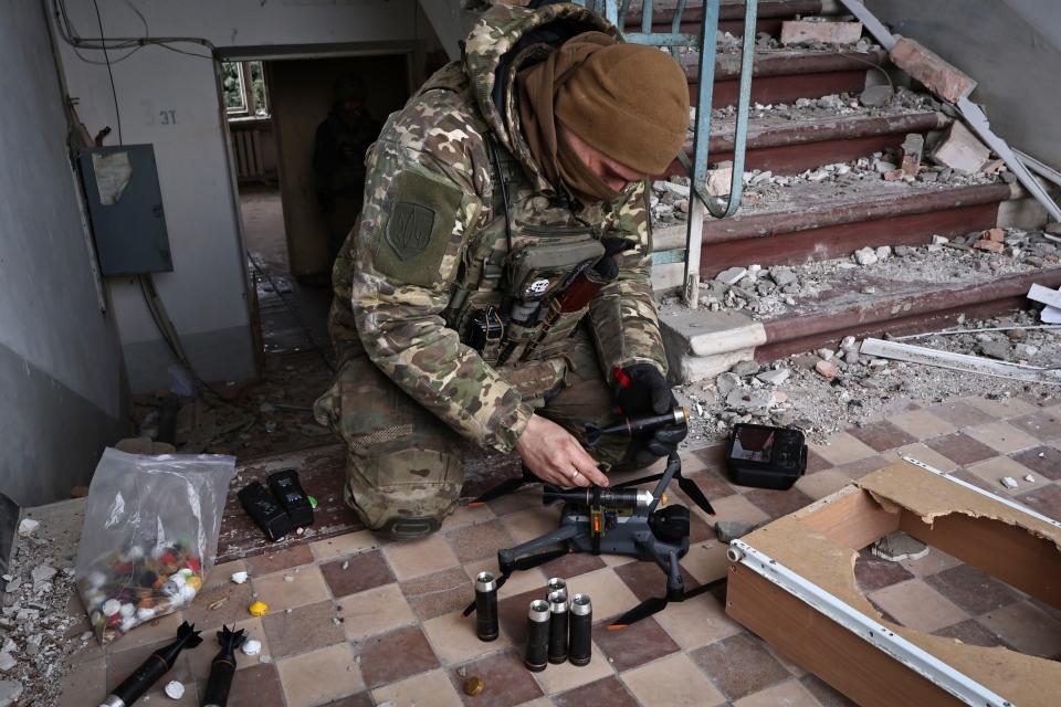 A Ukrainian soldier equips a drone with grenades in the area of the heaviest battles with the Russian invaders in Bakhmut March 15. (Roman Chop/AP)