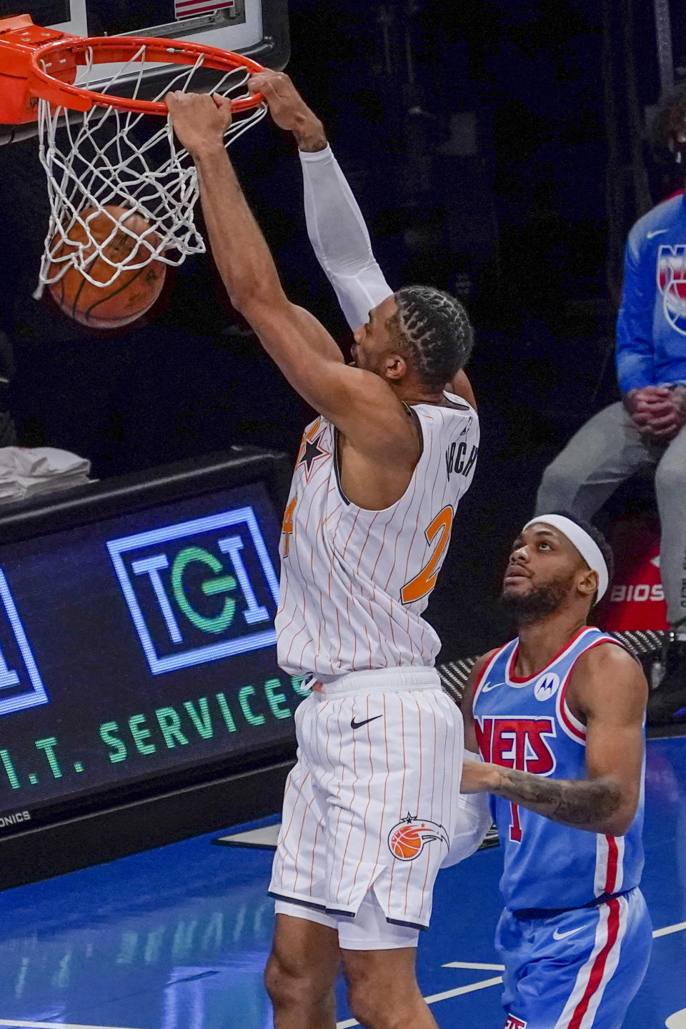 Orlando Magic center Khem Birch (24) dunks past Brooklyn Nets guard Bruce Brown during the first half of an NBA basketball game, Saturday, Jan. 16, 2021, in New York. (AP Photo/Mary Altaffer)