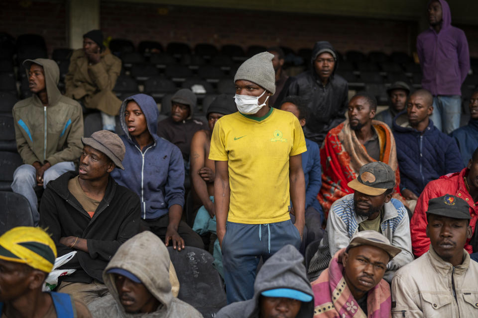 Homeless people stay at the Caledonian stadium downtown Pretoria, South Africa, Thursday April 2, 2020, after being rounded up by police in an effort to enforce a 21 day lockdown to control the spread of the coronavirus. Many of them being addicted, they are receiving methadone syrup from a local NGO, and were complaining about the lack of sanitizer and soap. The new coronavirus causes mild or moderate symptoms for most people, but for some, especially older adults and people with existing health problems, it can cause more severe illness or death.(AP Photo/Jerome Delay)