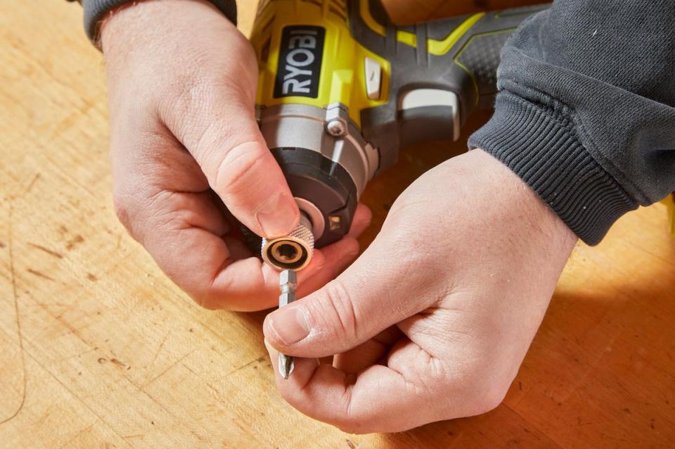 Handyperson inserts new bit in impact driver.