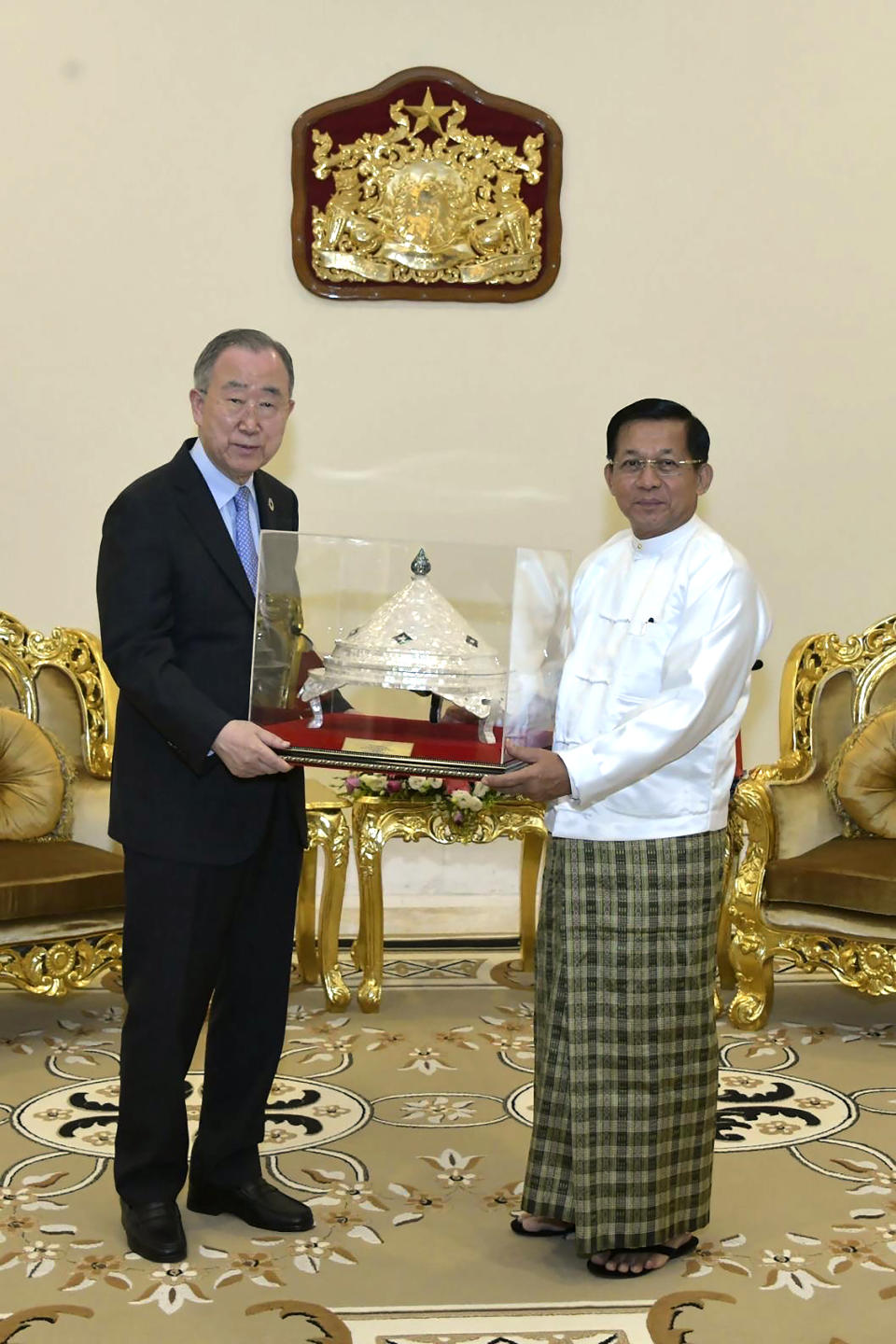 In this photo provided by the Myanmar Military True News Information Team, Senior Gen. Min Aung Hlaing, right, head of the military council, presents a gift to Ban Ki Moon, left, former U.N Secretary-General, during their meeting Monday, April 24, 2023, in Naypyitaw, Myanmar. (Military True News Information Team via AP)