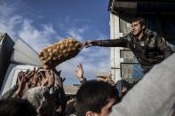 <p>Ein Helfer verteilt in Mossul im Irak Kartoffeln an Zivilisten. (Bild: AP Photo/ Manu Brabo) </p>