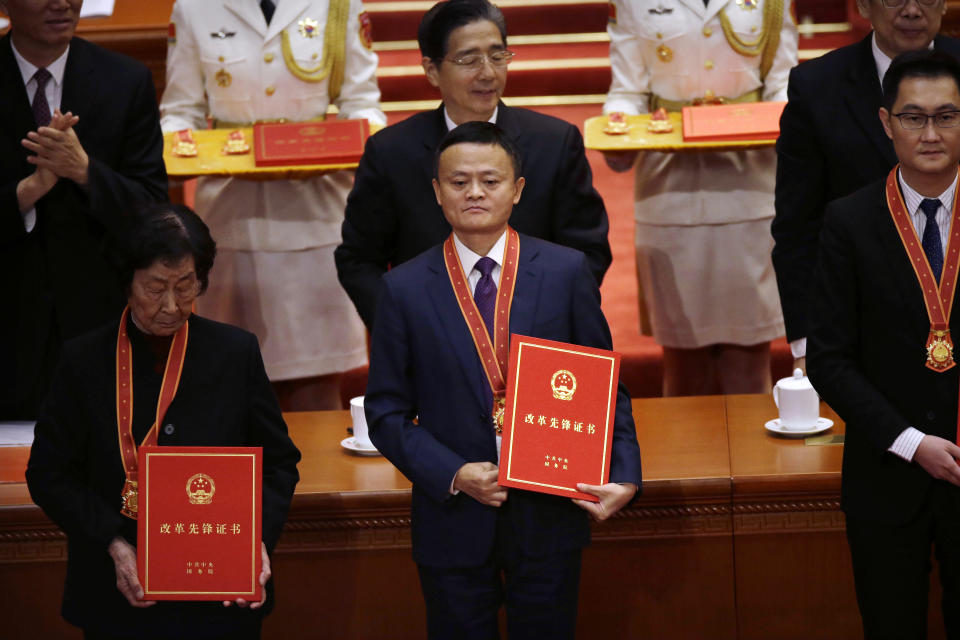 FILE - Jack Ma, center, then chairman of Chinese e-commerce firm Alibaba Group, stands during a conference to commemorate the 40th anniversary of China's Reform and Opening Up policy at the Great Hall of the People in Beijing, Dec. 18, 2018. Ma, China's most prominent entrepreneur and founder of Alibaba Group, the world's biggest e-commerce company, stopped appearing in public after he criticized regulators as being too conservative in an October 2020 speech. (AP Photo/Mark Schiefelbein, File)