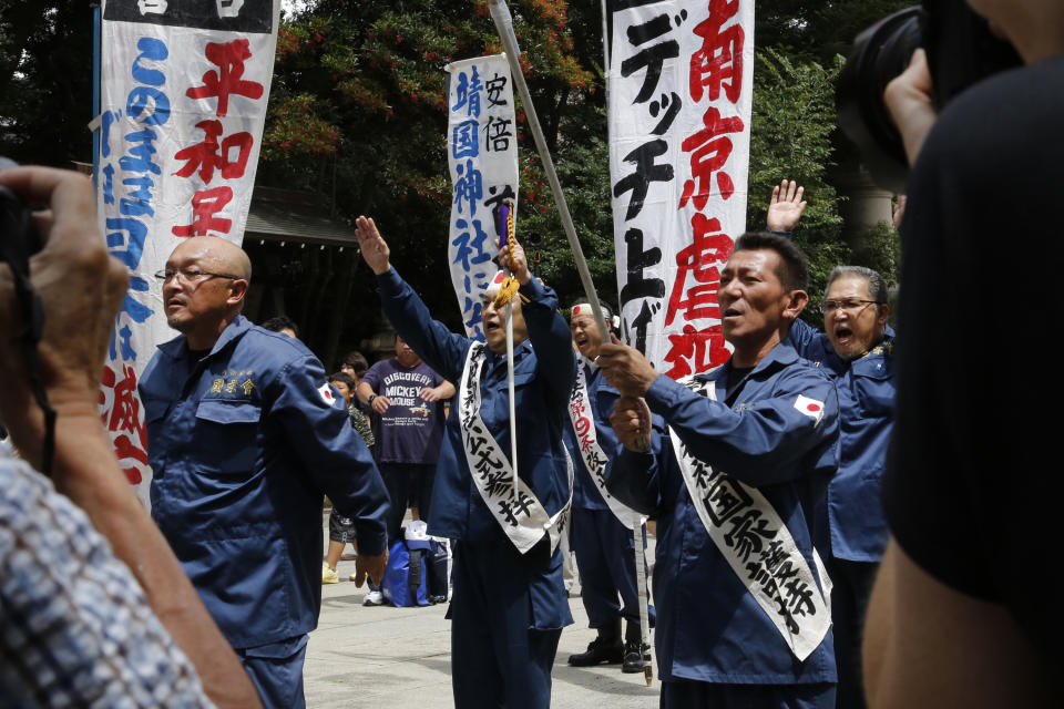 In this Aug. 15, 2019, photo, members of a right wing group visit Yasukuni Shrine in Tokyo. Some of Japan’s views on history could be seen recently when throngs of people flocked to Tokyo’s Yasukuni Shrine recently to pay respect to war dead, some carrying the rising-sun flag and banners that said, “Banzai to the emperor.” (AP Photo/Yuri Kageyama)