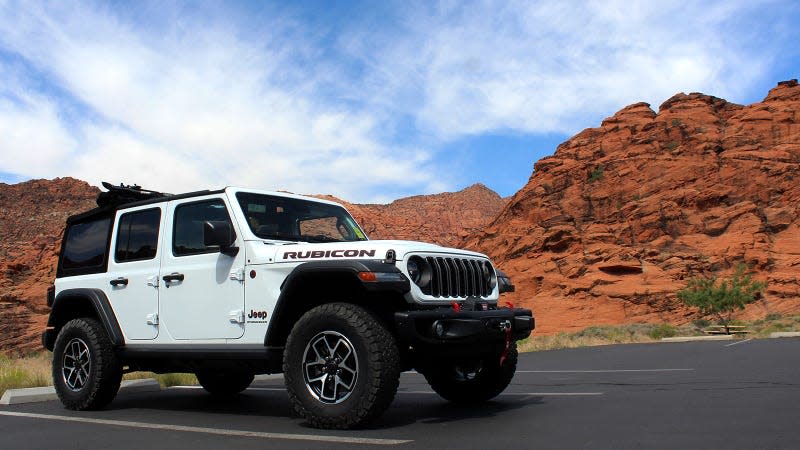 A photo of a white Jeep Wrangler parked in a canyon. 