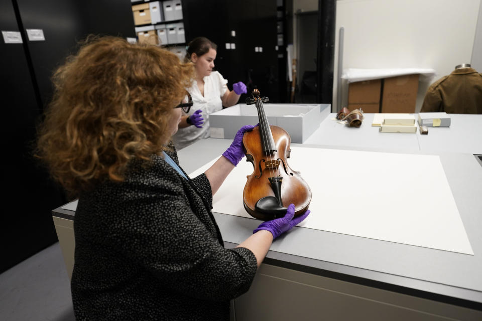 Kim Guise, curator for the National World War II Museum, shows a violin, hand made by Wilfred Lyon while a prisoner of the Germans, which will be on display at the new pavilion of the museum, in New Orleans, Friday, Sept. 29, 2023. The latest major addition to the museum is called the Liberation Pavilion. And it's ambitious in scope. The grim yet hopeful addition addresses the conflict's world-shaping legacy. (AP Photo/Gerald Herbert)